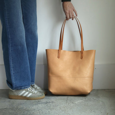 Full-grain vegetable-tanned leather tote in beige, fits a 13-inch laptop, handcrafted artisan bag.