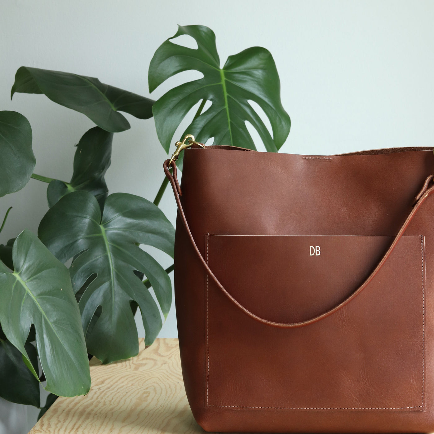 Handmade leather bag with gold monogram. Women's shoulder bag is simple and has front pocket and magnetic snap closure. Handmade with vegetable tanned leather in America by Juliette Rose Designs