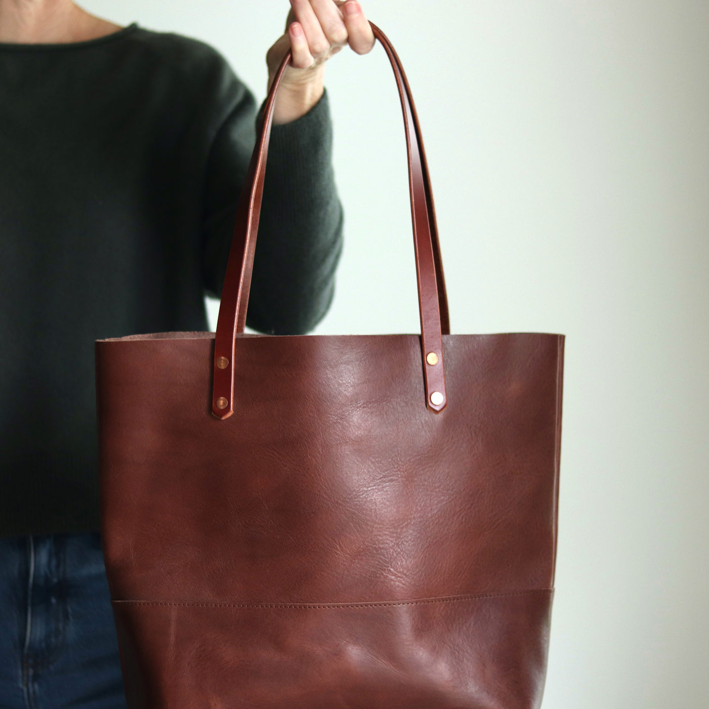Close-up of dark brown full-grain vegetable tanned leather texture with natural variations.