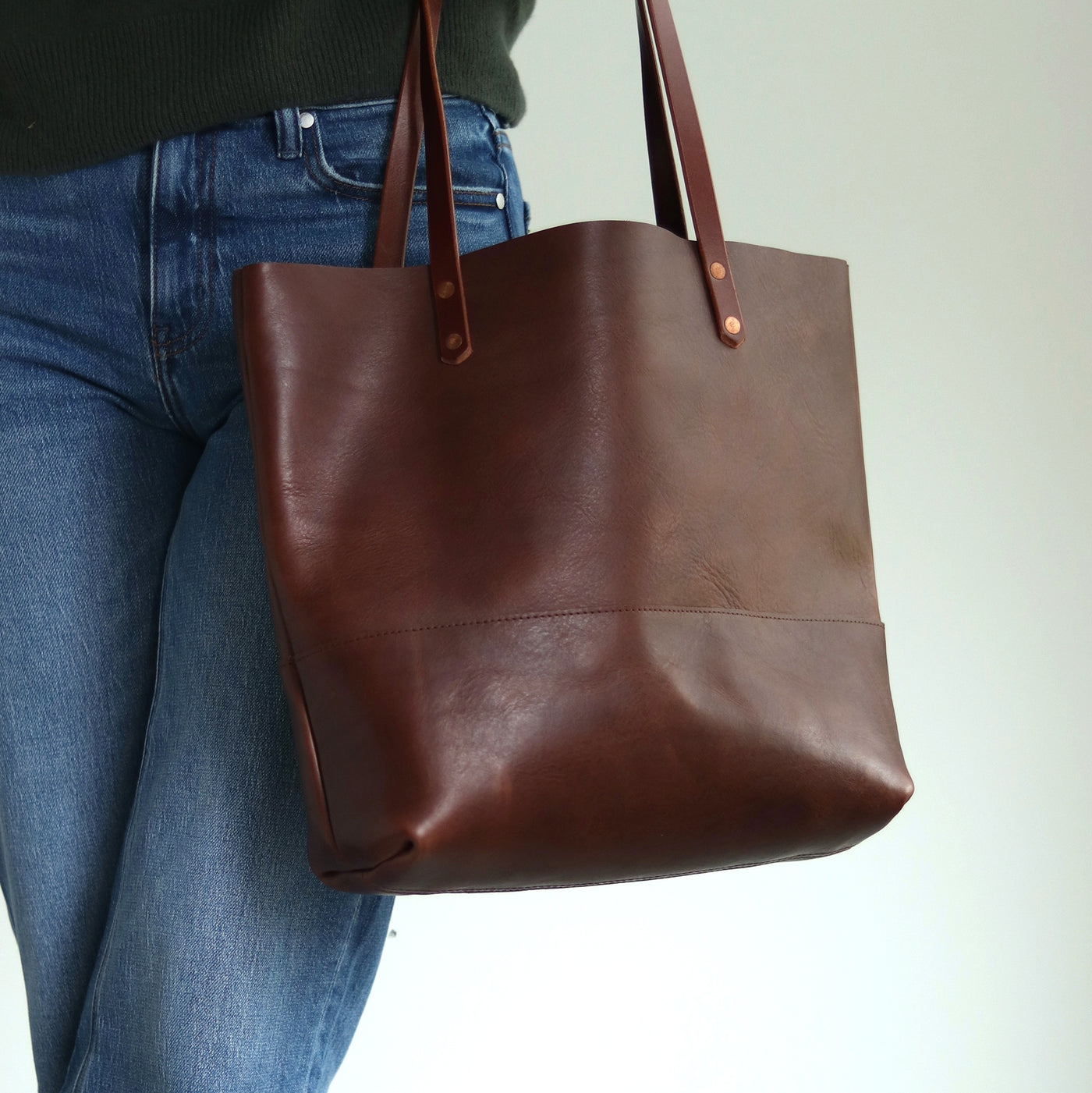 Full-grain vegetable-tanned Italian leather tote in dark brown with natural sheen and rich aroma.