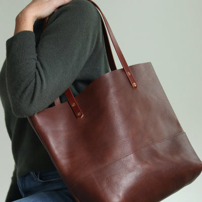 Minimalist dark brown Italian leather tote bag with hand-burnished straps and copper rivets, handcrafted in Vermont.