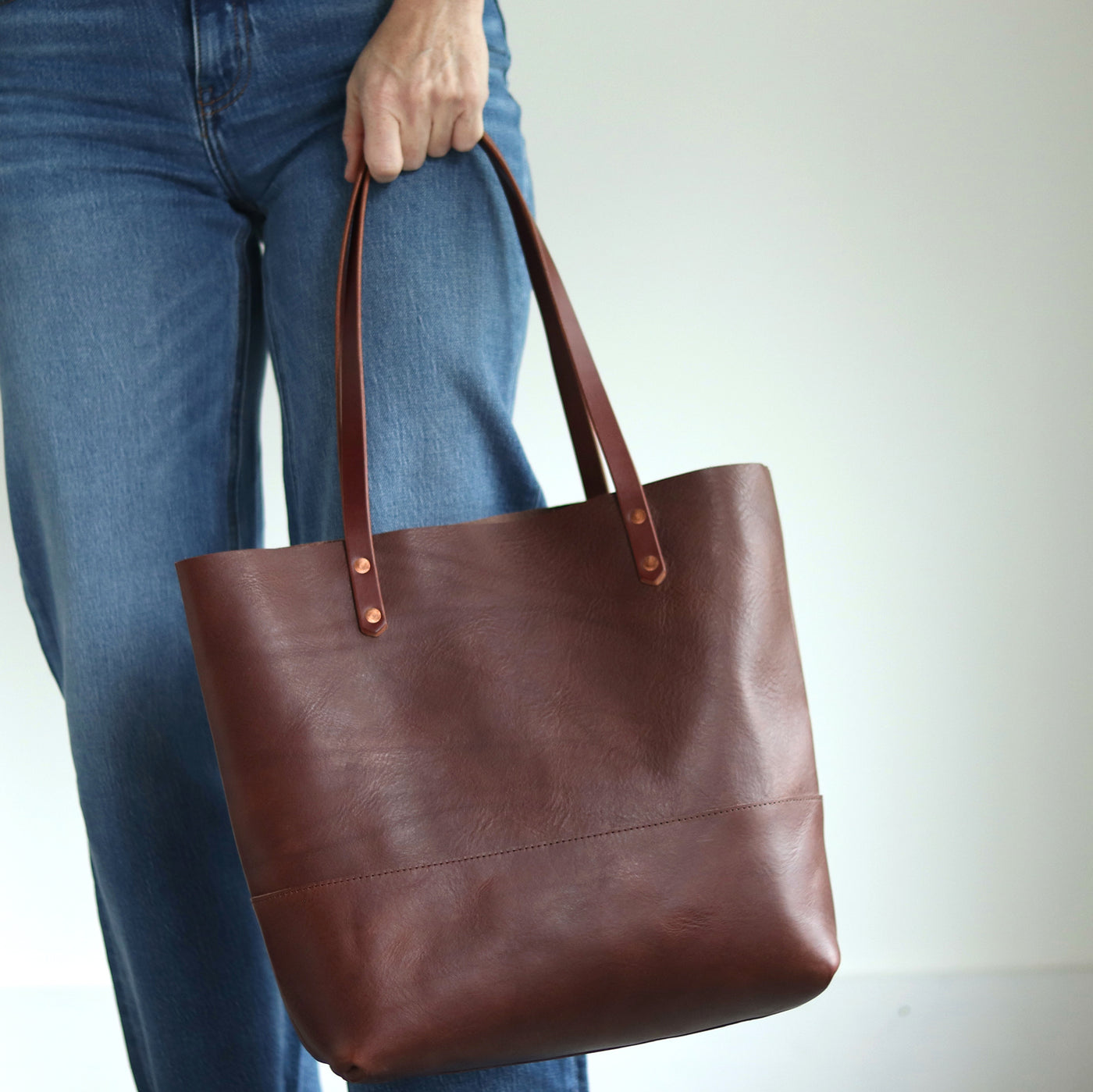 Minimalist dark brown leather shopper bag handcrafted with Italian vegetable tanned leather and copper rivets