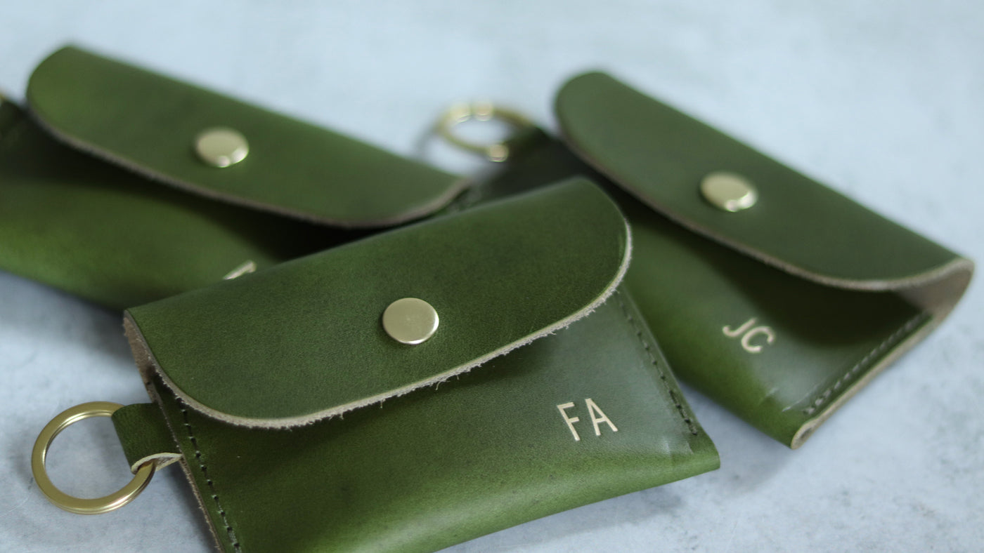 Personalized green leather card wallets with gold foil monogram, handmade with vegetable tanned leather and a brass snap and keyring