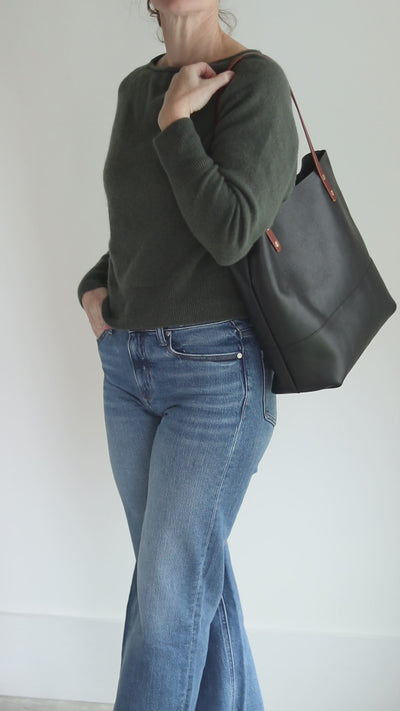 Black pebbled Italian leather tote bag with contrasting brown bridle straps and copper rivets.