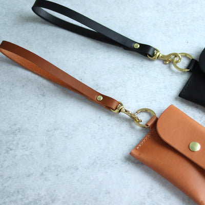 Leather wrist straps handmade with vegetable tanned leather and brass and gold hardware. Add a slim leather wrist strap to your clutch bag, by Juliette Rose Designs. 4 colors are available in black, cognac brown, tan, and natural beige.